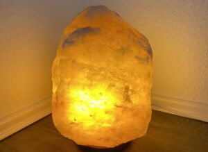 Eine Steinsalzlampe die in einem hellen orange Ton leuchtet und als Titelbild für den Artikel weibliche und männliche Energien fungiert
